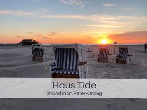 a group of chairs on the beach at sunset at Entspannter Nordsee-Urlaub in naturnahen Ferienwohnungen im Haus Tide in Böhl