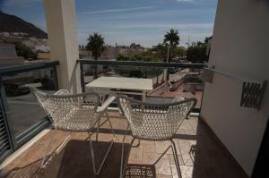 uma varanda com 2 cadeiras e uma mesa na varanda em Hotel La Posada De Paco - Spa & Adults Friendly em San José