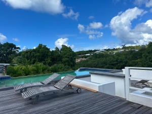 a deck with two chairs and a swimming pool at Studio Terres Basses, Saint-Martin in Les Terres Basses
