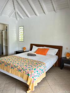 a bedroom with a large bed with orange pillows at Studio Terres Basses, Saint-Martin in Les Terres Basses