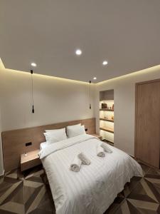 a bedroom with a white bed with towels on it at The Cozy Residence in Veria