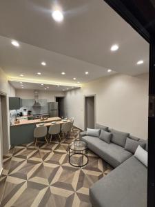 a living room with a couch and a kitchen at The Cozy Residence in Veria