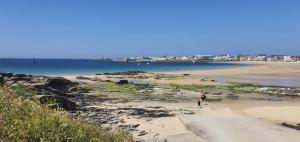 eine Person, die am Strand in der Nähe des Wassers steht in der Unterkunft ESCAPADE FAMILIALE A LA MER in Quiberon