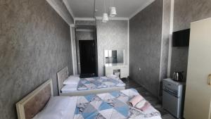 a bedroom with two beds and a mirror at Butik in Ganja