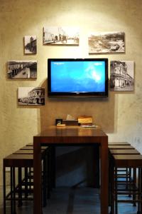 a television on a wall with a table and stools at The Album Hotel in Patong Beach