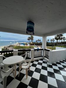 een veranda met een tafel en stoelen en de oceaan bij CHY dreams in Cabo Negro