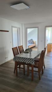 een eetkamer met een tafel en vier stoelen bij Apartment Hermeskeil 3 in Hermeskeil