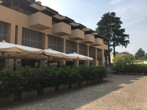 a building with umbrellas and bushes in front of it at Soggiorno ai Portici in Vimercate