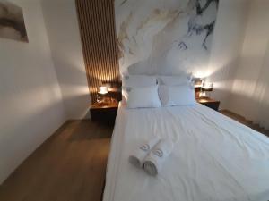 Ein Paar Hausschuhe liegt auf einem weißen Bett. in der Unterkunft Apartament w Czarnowąsach 3 in Oppeln
