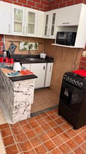 een keuken met witte kasten en een zwarte kachel bij Curazao in Punta Hermosa
