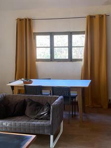 a living room with a table and a couch at Charmant chalet in Auffargis