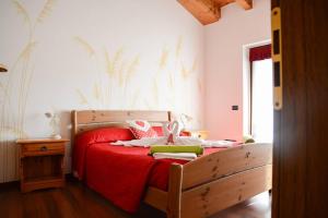 a bedroom with a bed with a red bedspread at Villa Nataly in Crosano