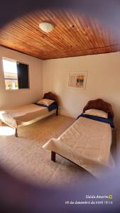 2 Betten in einem Zimmer mit Holzdecke in der Unterkunft Pousada Sete Montanhas in Ibicoara