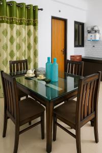 a dining room table with two chairs and blue bottles on it at 2 Bhk Mayra Homes in Raipur
