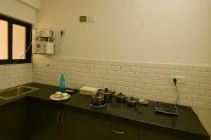 a kitchen counter top with pots and pans on it at 2 Bhk Mayra Homes in Raipur +14 photos