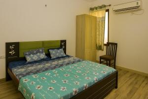 a bedroom with a bed and a chair and a window at 2 Bhk Mayra Homes in Raipur