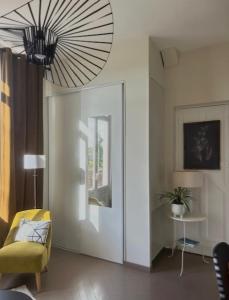 ein Wohnzimmer mit einem gelben Stuhl und einem Kronleuchter in der Unterkunft Studio avec grande terrasse in Saint-Valéry-en-Caux