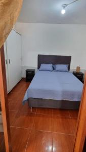 een slaapkamer met een bed en een houten vloer bij Curazao in Punta Hermosa