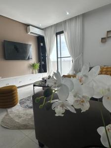 een woonkamer met een bank waarop witte bloemen staan bij Studio au point E in Dakar