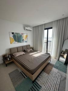 a bedroom with a large bed and a large window at Studio au point E in Dakar