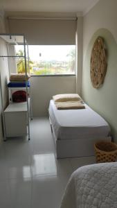 een slaapkamer met twee bedden en een raam bij Seu refúgio em Maragogi in Maragogi +15 foto's