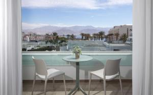 a table and chairs on a balcony with a view at סי סייד - אביה סונסטה in Eilat