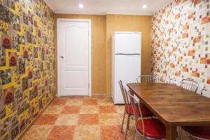 a kitchen with a table and a refrigerator at Guest House Asahi in Stryi