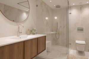 a bathroom with a sink and a shower with a mirror at סי סייד - אביה סונסטה in Eilat +15 photos