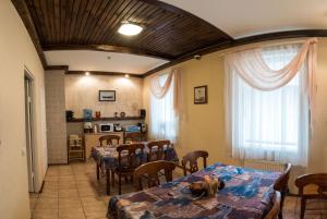 a dining room with tables and chairs and a kitchen at Leo in Daugavpils