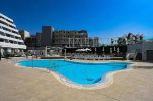 a large blue swimming pool in a city at סי סייד - אביה סונסטה in Eilat