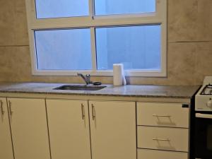 een keuken met een spoelbak en een raam bij Edificio-Pellegrini PA in Bragado +2 foto's