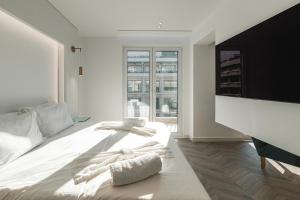 una camera da letto con un letto bianco con asciugamani sopra di White Rose Athens Residence ad Atene