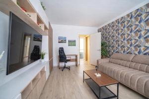 een woonkamer met een bank en een tv bij Comfort 28 Great Value Apartment in Miskolc
