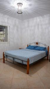 Bett in einem Zimmer mit einer Decke in der Unterkunft Villa de luxe vue sur mer in Moulay Bousselham