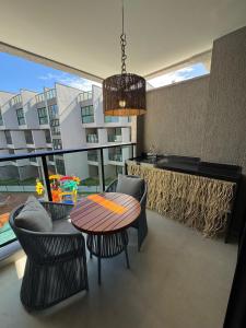 a dining room with a table and chairs and a kitchen at Nomar Carneiros - Flat Beira-mar in Tamandaré