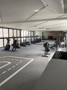 a gym with rows of treadmills and exercise bikes at Nomar Carneiros - Flat Beira-mar in Tamandaré