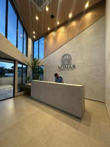 a man sitting at a counter in a lobby at Nomar Carneiros - Flat Beira-mar in Tamandaré +16 photos
