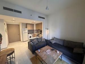 een woonkamer met een bank en een tafel bij Full apartment at excellent Community in Sharjah