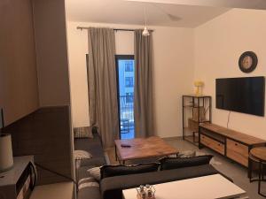 een woonkamer met een bank en een tv bij Full apartment at excellent Community in Sharjah