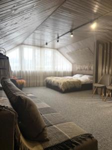 ein Zimmer mit 2 Betten und einem Sofa darin in der Unterkunft GORY & TYSHA Гори і Тиша in Yavoriv + 9 Fotos