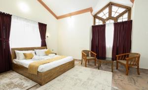 a bedroom with a bed and a table and chairs at Bloom Fort Villa in Kannur