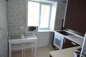 ノヴォシビルスクにあるApartments on Dusi Kovalchuk 266/1の白いテーブルと窓付きのキッチン