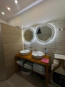 a bathroom with two sinks and two mirrors on the wall at KARTAL centar apartment in Bihać +52 photos