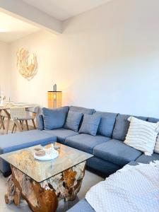 格兰高伯Zephyr House 3BR Pool, Rooftop & Ocean View的客厅配有带咖啡桌的蓝色沙发