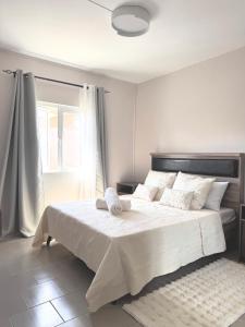 格兰高伯Zephyr House 3BR Pool, Rooftop & Ocean View的卧室里有一张白色的大床，床边有一扇窗户