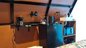 a kitchen with a refrigerator and a microwave at Chalé Ecológico para 2 pessoas in Bombinhas +9 photos
