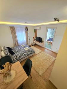 een slaapkamer met een bed, een tafel en een raam bij Panoramic Nest in Vrnjačka Banja