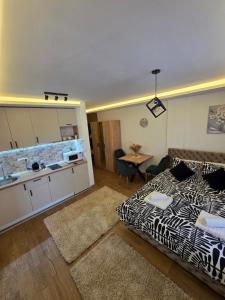 een woonkamer met een bed en een keuken met een wastafel bij Panoramic Nest in Vrnjačka Banja