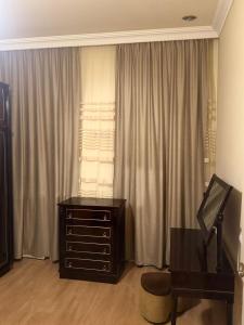 Cette chambre comprend une commode, un bureau et une fenêtre. dans l'établissement NOYemi, à Goris