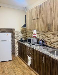 une cuisine avec des armoires en bois et un réfrigérateur blanc dans l'établissement NOYemi, à Goris